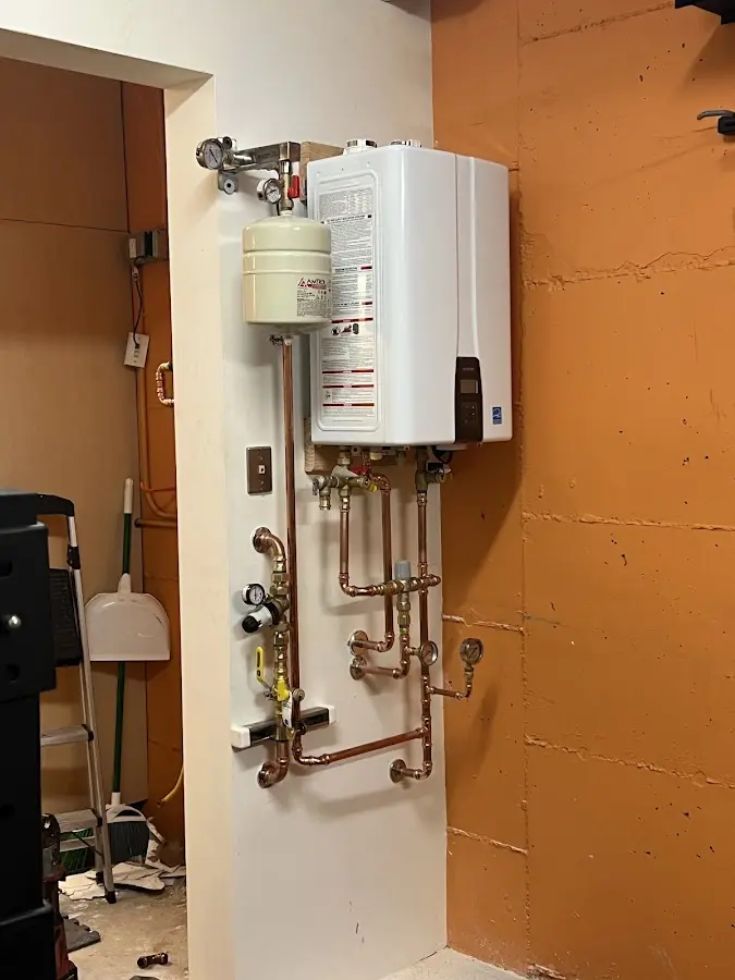 Plumbing technician inspecting water heater connections in Steelton